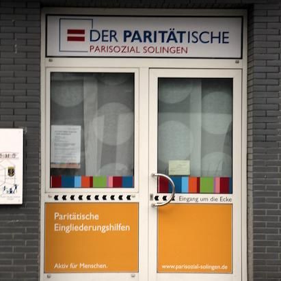 Banner und Eingangsbereich von Pari Sozial – bekannter Schriftzug Der Paritätische und bunte Tür.